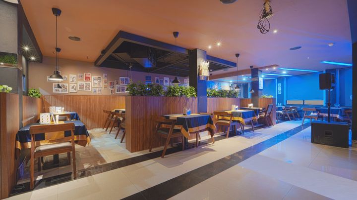 Tables in the bar under blue and warm lighting