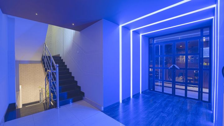 Blue neon light lines framing the bar entrance