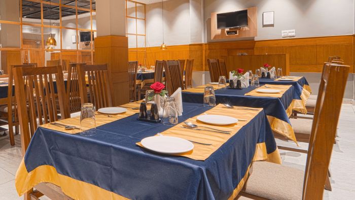 Restaurant dining room with wooden chairs and set tables
