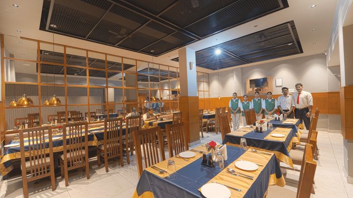 Restaurant staff beside set dining tables