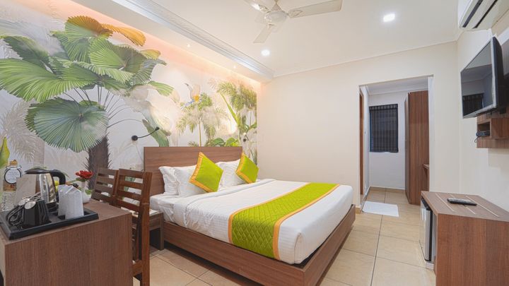 Room with a king bed, a desk and a wall-mounted television