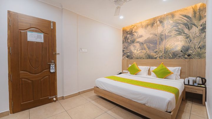 Room seen from the entrance, with a leaf mural above the bed